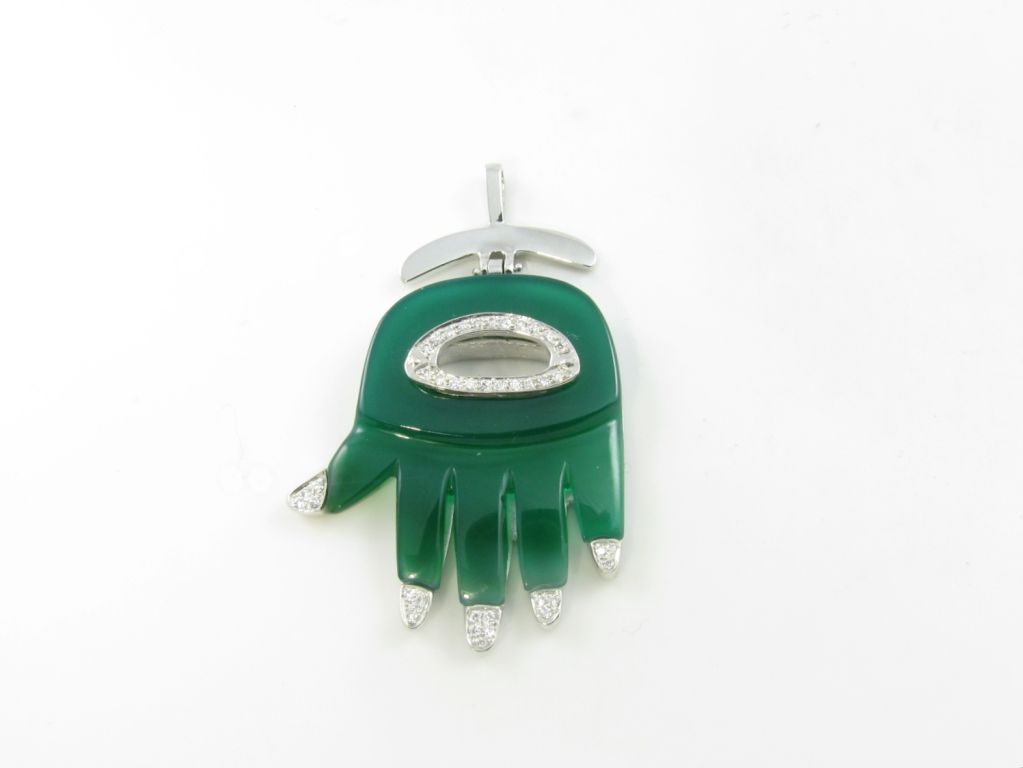 An 18 karat white gold, green onyx and diamond small size Hamsa hand pendant.  Signed A. Cipullo.