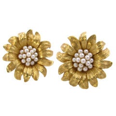 A stylish pair of textured gold and pearl flower earrings.
