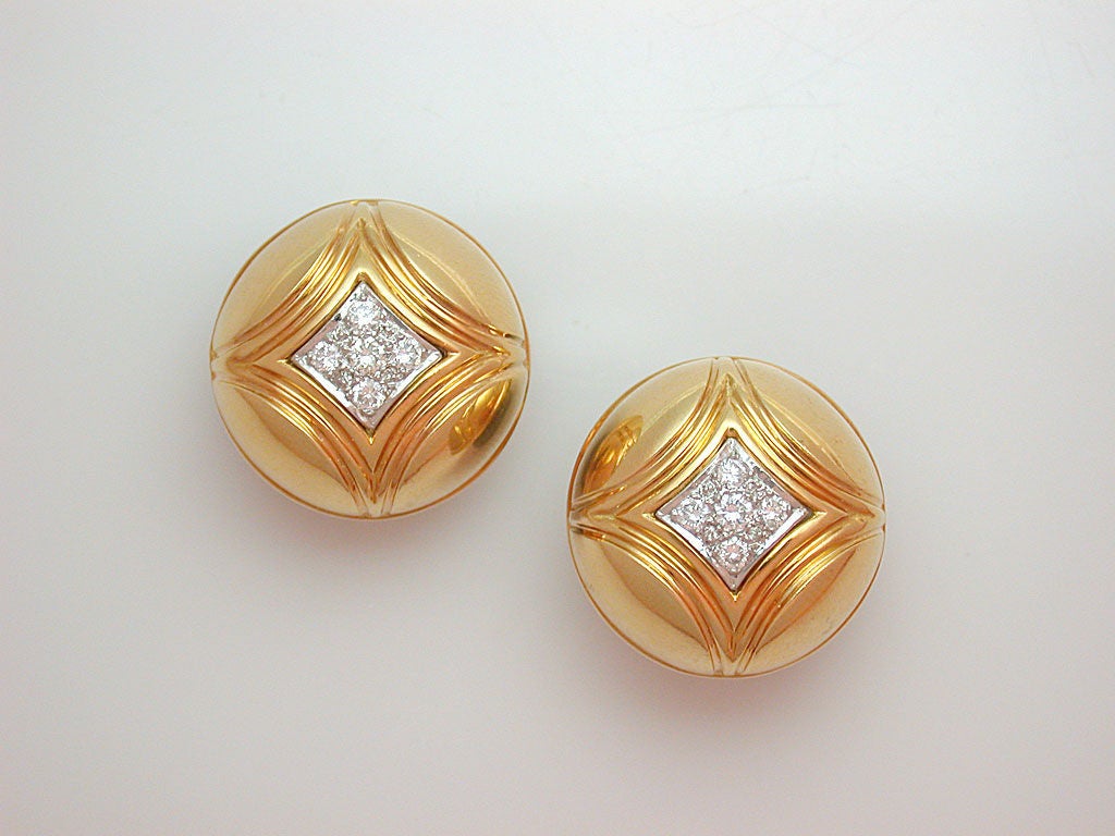 A great earring for every day, the domed yellow gold buttons ribbed indicating quadrants around white diamond centers set in white gold (10 circular-cut stones weighing approximately 0.50 carats total) with sturdy clip backs and ridged pads for