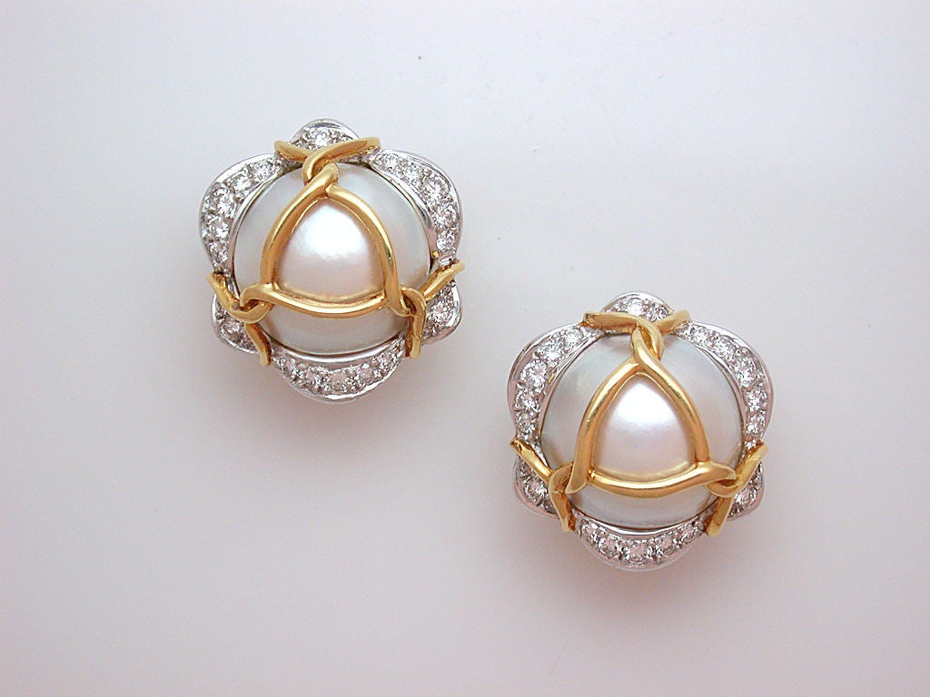 The elegant earclips centering 17mm white mabé pearls, edged with undulating strips of white diamonds set in platinum, and wrapped with polished yellow gold rope, signed Verdura.  An original Verdura design, this model was renamed 