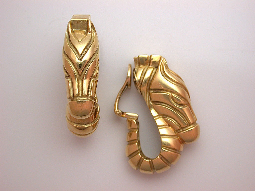 The heavy earrings designed as polished yellow gold zebras, with deep grooves imitating its stripes, sturdy clip backs and ridged pads for grip, signed Judith Leiber in script and stamped 18K, circa 1990. Judith Leiber only produced fine jewelry for