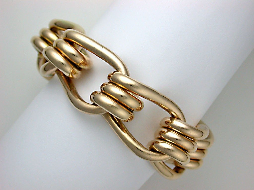The stylish bracelet built from 8 coiled tubular links to imitate the spring of a mousetrap, unsigned, with two European scallop-shell marks for 14kt gold, heavy, circa 1945.