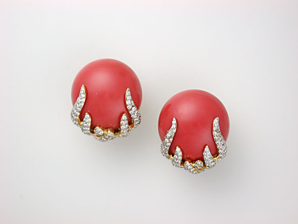 The 17mm deep orange coral cabochons backed with polished yellow gold cups and held at their bases with pavé-set diamond flames in the spirit of Henry Dunay, with large omega clip backs and ridged pads for grip (posts can easily be added), stamped
