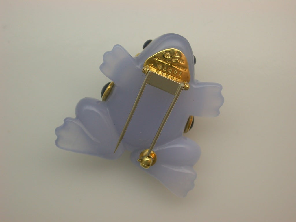 The translucent greyish-blue chalcedony frog brooch set with cabochon sapphires (approximately 20 carats total weight) and gold pyramid accents, signed Seaman Schepps, numbered #10376, in excellent condition, measuring approximately 1 1/2 inches