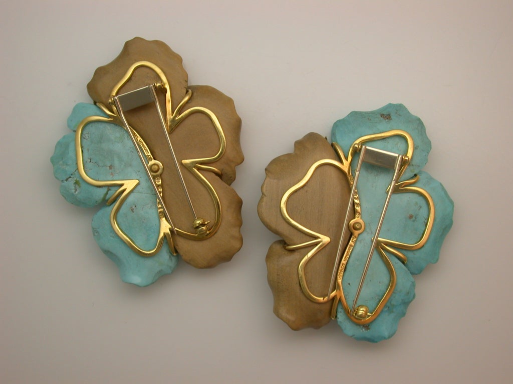 The pair of large brooches realistically designed as poppy flower heads, with carved walnut wood petals decorated with cabochon turquoise stones, carved turquoise petals, and faceted citrine centers extending polished yellow gold tendrils, signed