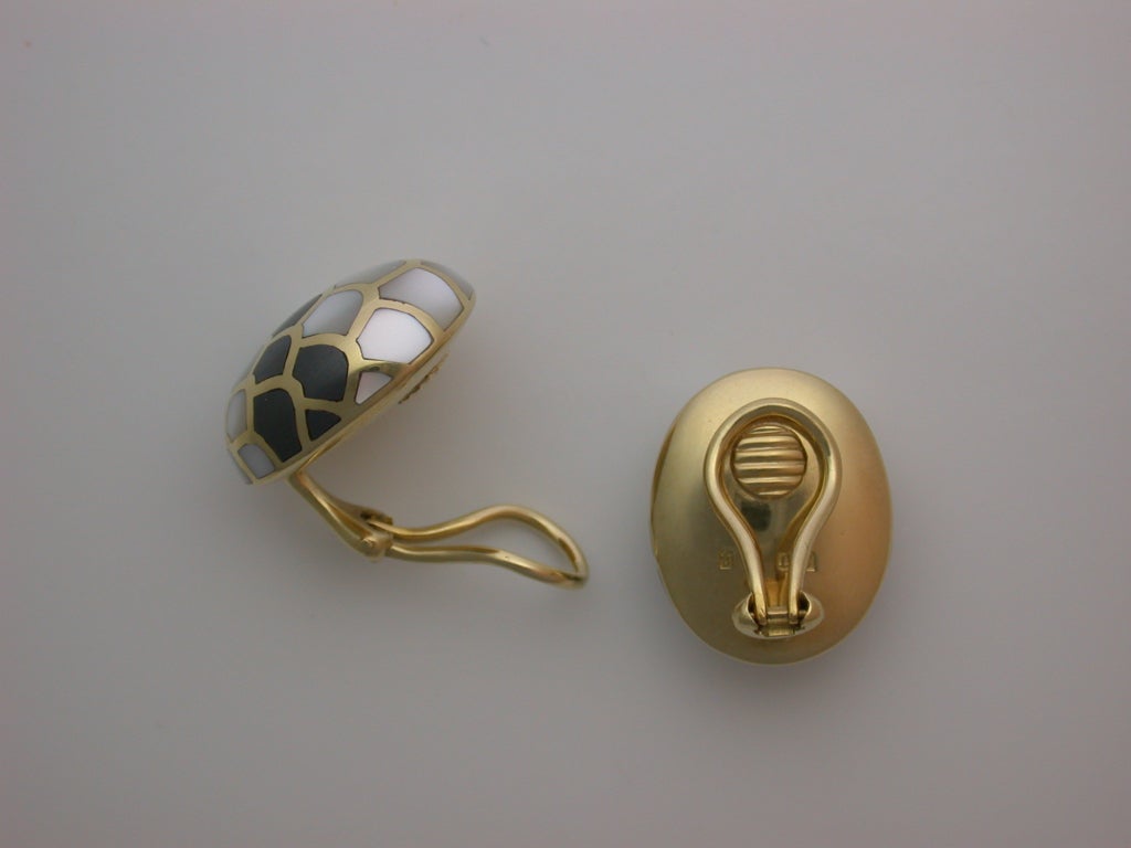 The polished yellow gold domed ovals inlaid with light grey and dark grey mother-of-pearl shell 