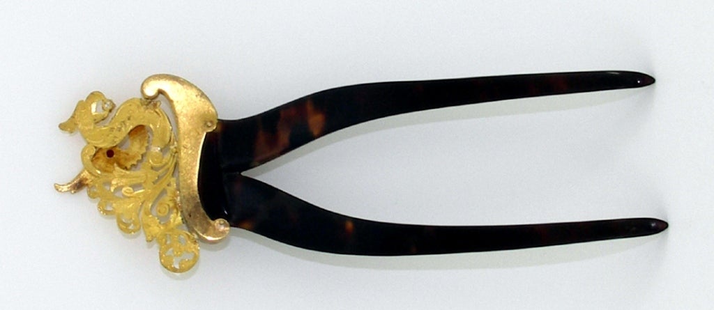 A gorgeous Victorian era back comb crafted in 18K gold, atop of tortoise shell teeth. Garnished with two beautifully colored round faceted rubies, and one old mine cut diamond, it has great style.