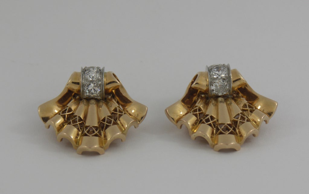 A pair of 18K yellow gold and platum clips. Made in France during the 1940's-1950's, they are set with approximately 1.33ct of Old European, and Transitional cut diamonds, of overall F/G color and VS1-SI1 clarity. Beautifully formed and pierced,