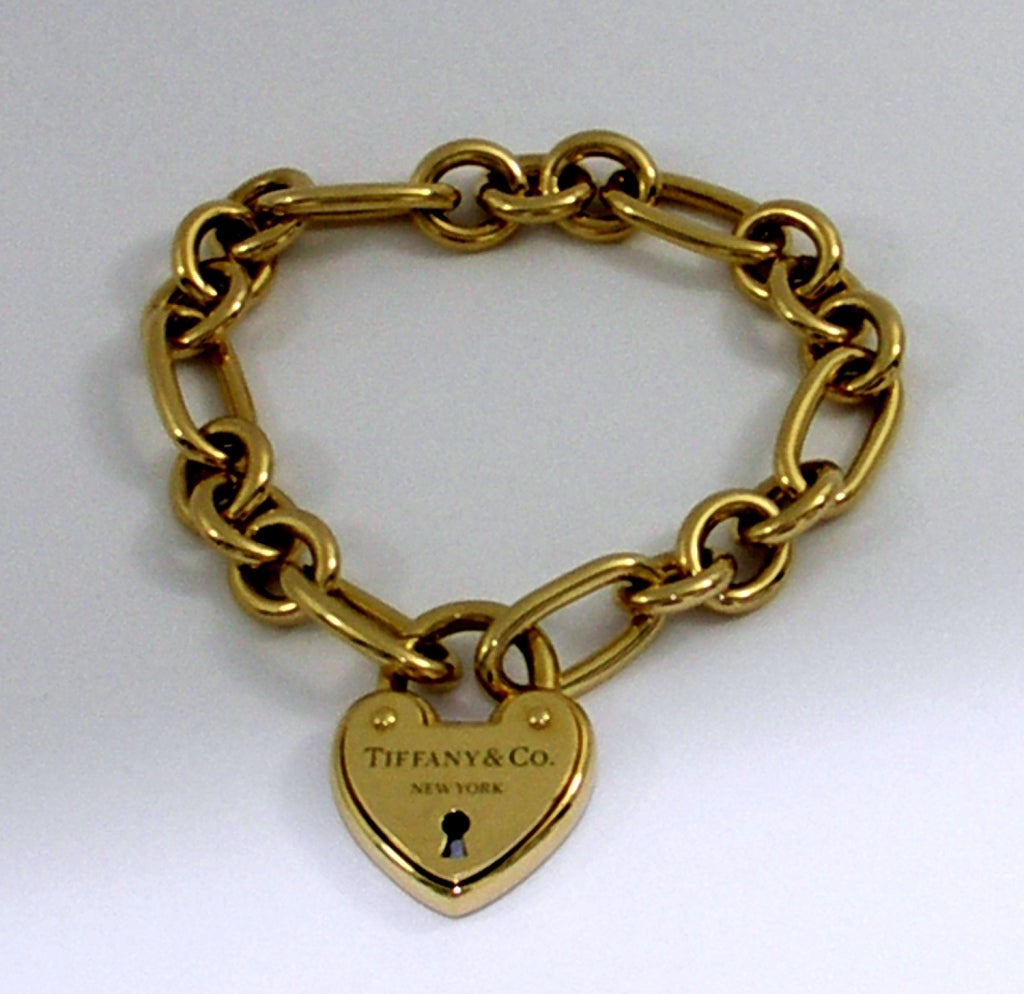 One ladies 18K yellow gold bracelet with heart-shaped clasp measuring 7/8 of an inch wide and 1 1/8 inches long. The links are 3/8 of an inch wide with alternating links measuring 3/4 of an inch long.