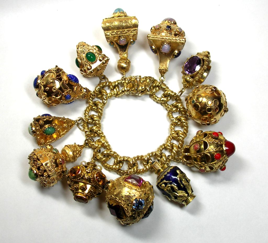 Incredible ladies 18K Yellow Gold Charm bracelet measuring seven inches long. This gorgeous bracelet has twelve Etruscan revival style charms set with assorted gemstones and pearls.