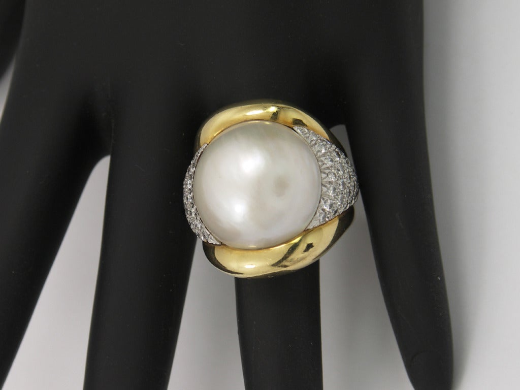 One ladies 18K yellow gold ring by Andrew Clunn set with assorted round brilliant cut diamonds in platinum sections, totaling approximately 1.33ct, of overall F/G color and VS1/VS2 clarity. The center-piece of this ring is a 19mm mobe pearl with