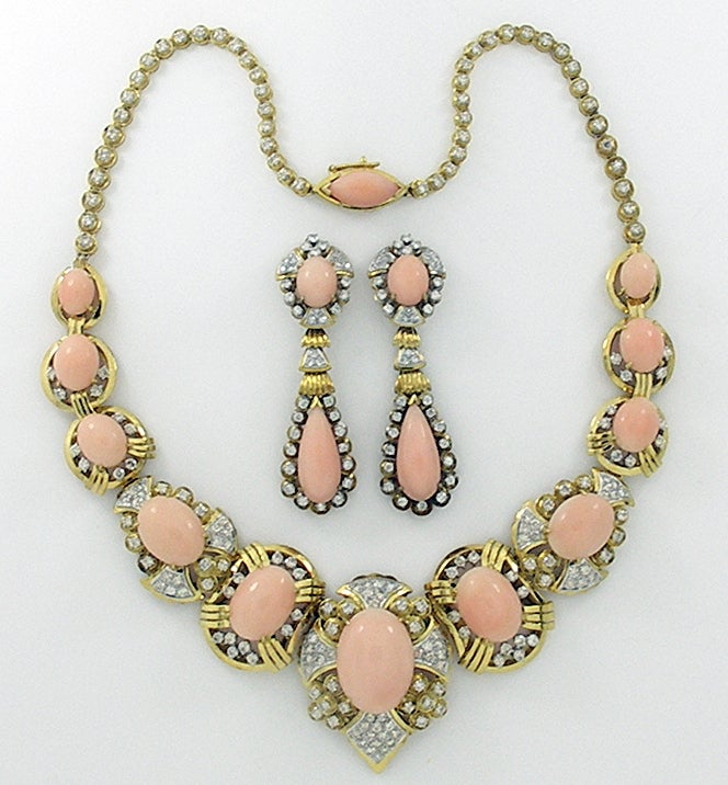 Part of a 3 piece angel skin coral suite, this lovely necklace is sold separately. Eleven oval shaped, angel skin coral cabochons are set in 18K yellow gold, with 177 diamonds weighing an approximate total weight of 6.35CT. The diamonds are of