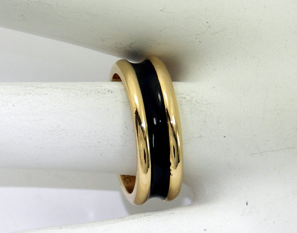 One ladies 18K yellow gold band by Tiffany & Co. with a recessed center, which enameled in black for a bold appearance. Measuring a quarter of an inch wide and a ring size 6.5, it is perfect for stacking, such as in conjunction with