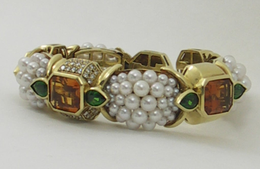 One ladies 18K yellow gold bracelet, with four sections comprised of cultured pearls. Designed by Stevens, this bracelet features three sections, each set with one emerald cut citrine, and two pear shape Tsavorite garnets. The citrine are a rich