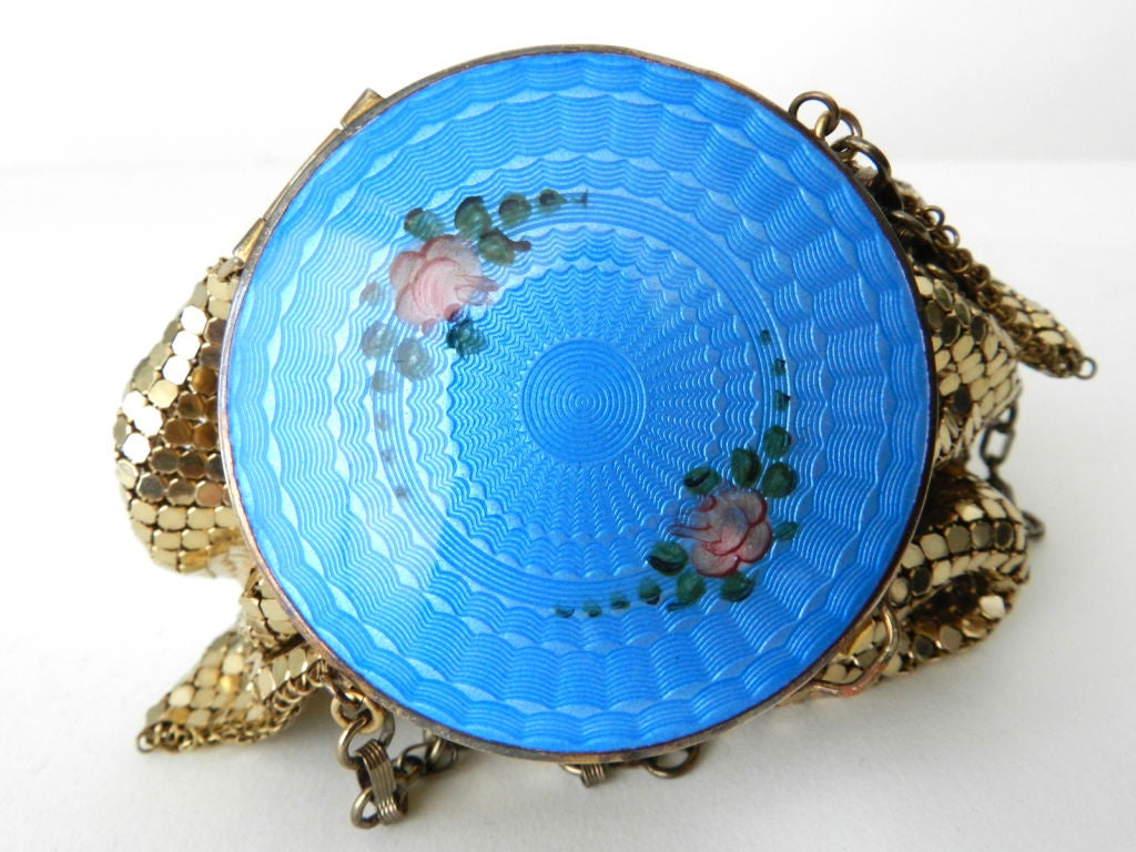 Vintage collectible 1930's Art Deco vanity compact purse by Evans.  Goldtone armor mesh body with chain strap and blue guilloche enamel top.  Compact has original rouge, puff, and flip up mirror.  Excellent vintage condition with no damage to metal