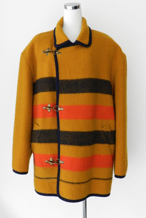 Hermes Vintage men's coat. Mustard colour body with midnight navy and orange stripes.  Edged in midnight navy fabric. boiled wool.  Three large metal hook closures.

Measurements:

tagged size 50

Shoulder to shoulder seam 24