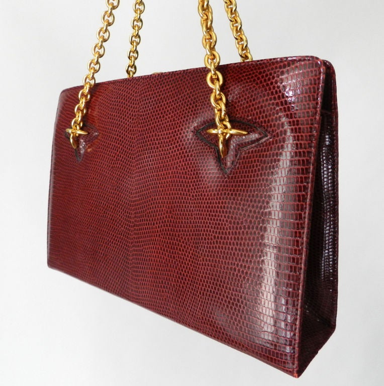 Vintage circa 1960's dark burgundy red lizard skin purse by Gucci.  Two heavy goldtone metal chain handles, small interior zip compartent and matching coin pouch.  Excellent vintage condition.  Measures 9.5
