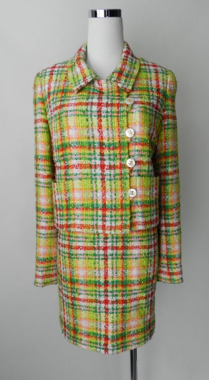 Vintage Chanel 97P skirt suit. Bright lime green, kelly green, red, and orange against white with lime silk CC logo lining.  Jacket has 5 mother of pearl and goldtone CC logo buttons at left side and 4 buttons at each cuff. Interior hem has goldtone