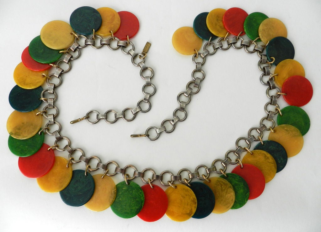Vintage circa 1960's / 1970's bakelite disc link belt by Yves Saint Laurent.  Fastens with hooks on each end of chain and has the YSL metal hang tag. Very good vintage condition, with some wear to the main metal chain.  Total length is 38 inches and
