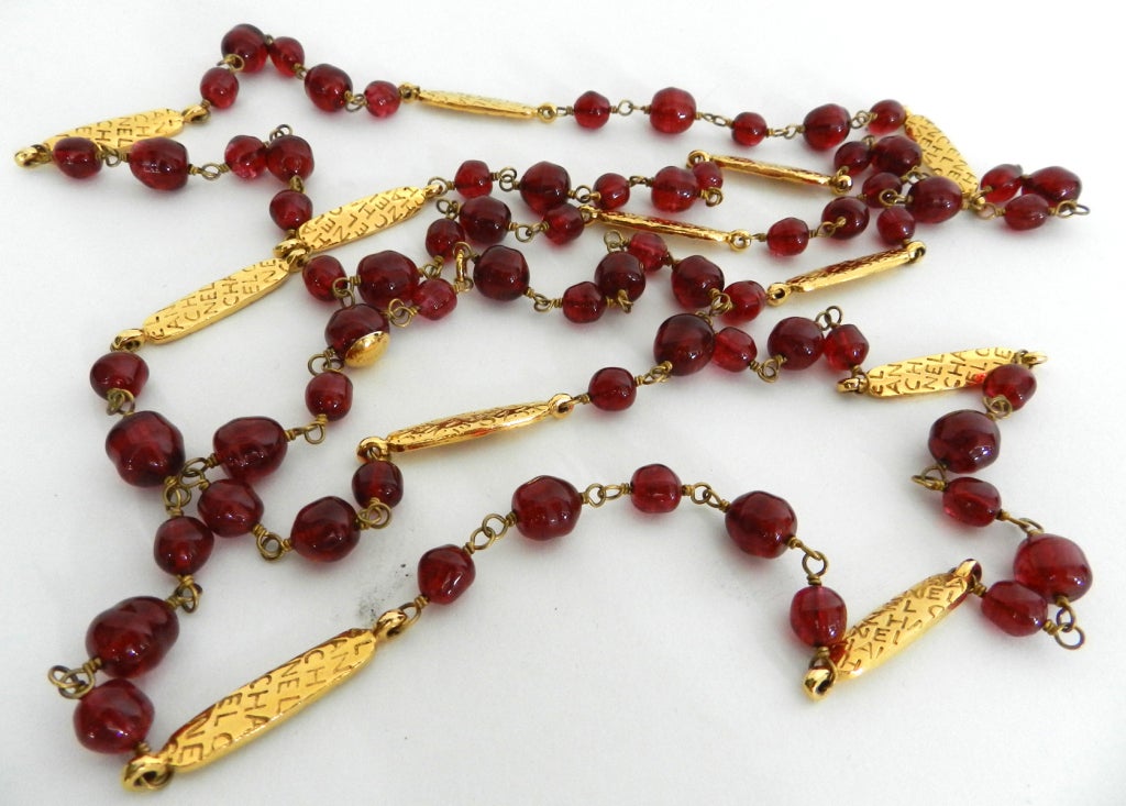 Chanel red glass beaded necklace with Chanel logo goldtone bars. Necklace hangs down 32