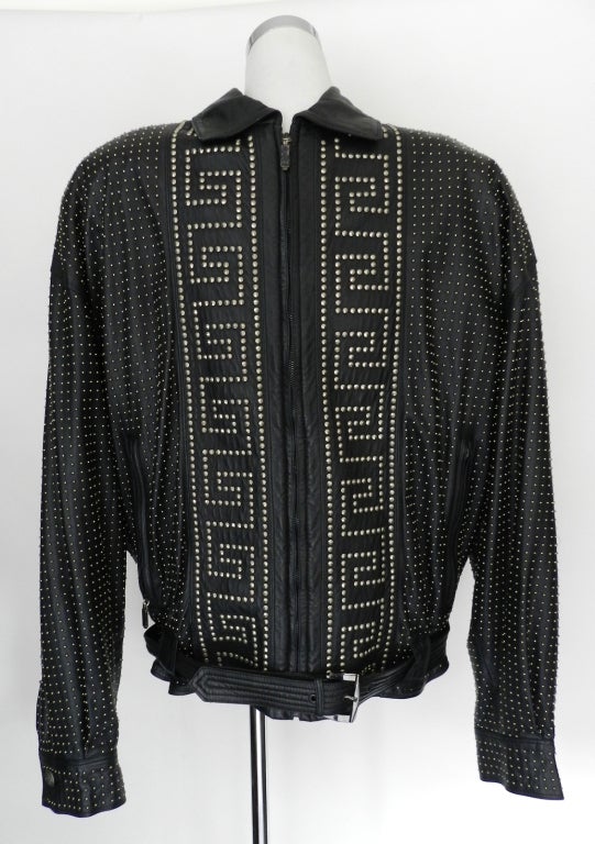 Circa 1993 vintage Gianni Versace black leather jacket for men.  Silvertone studs, medusa head buttons at cuffs, black silk jacquard lining, belted at waist. Excellent previously owned condition. Simiar jacket is shown pictured from Versace book.