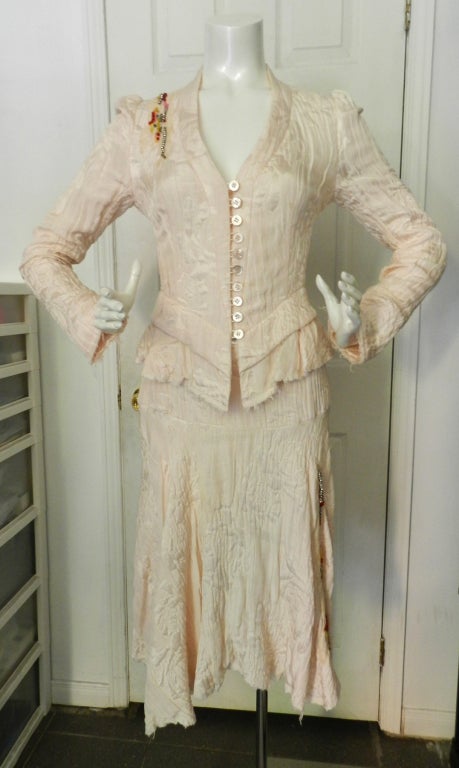Christian Lacroix pink textured skirt suit. Light shell pink colour. Raw unfinished hems, fitted jacket with shell buttons, glass and rhinestone beaded accents, asymmetrical hemline on skirt. Excellent previously owned