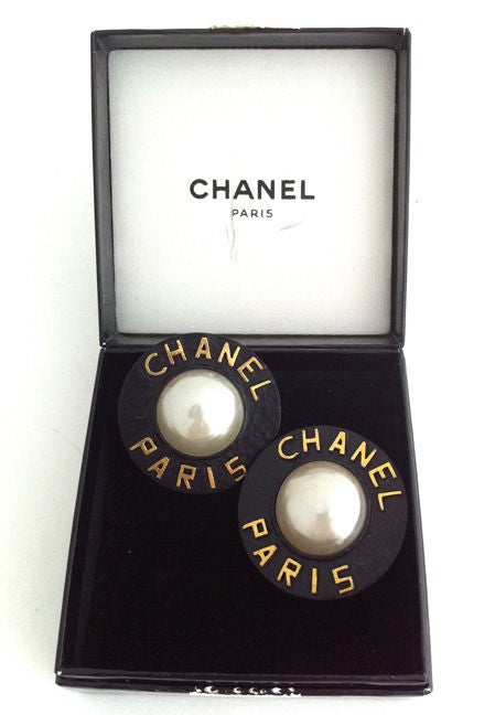 Vintage Chanel large clip earrings.  Black enamel on metal with gold logo and large faux mabe pearl. Measures 1 5/8