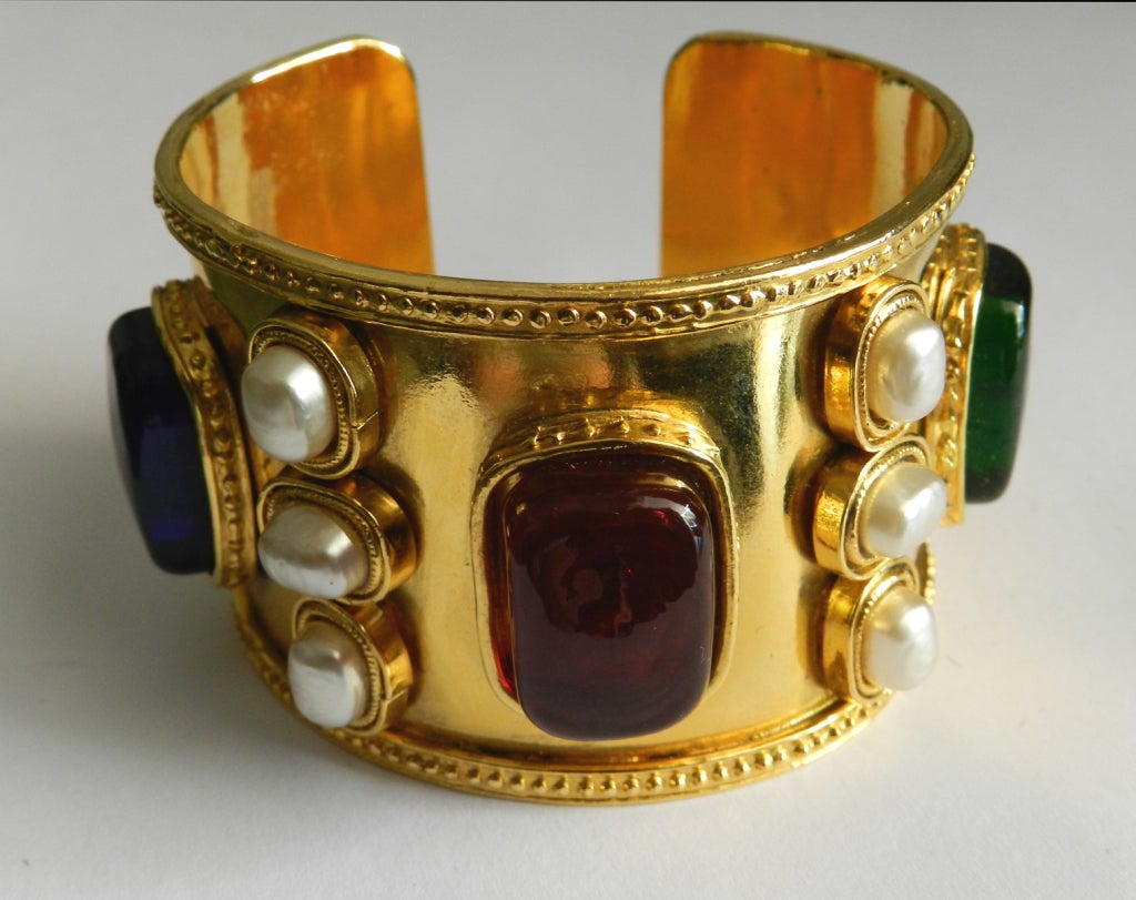 Vintage circa 1980's Chanel cuff. Stamped season 23. Goldtone metal cuff with red, green, and cobalt blue Gripoix glass, 12 baroque faux pearls, Byzantine influence design. Measures 1.75