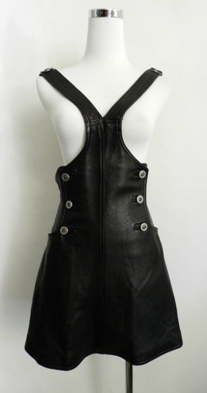 Vintage circa early 1990's Gianni Versace black leather dress. Overalls suspender style design, a-line skirt, back zipper, gunmetal silver colour medusa head details. 

Measurements:
USA size 0 / Extra small
Tagged size IT 38
waist up to