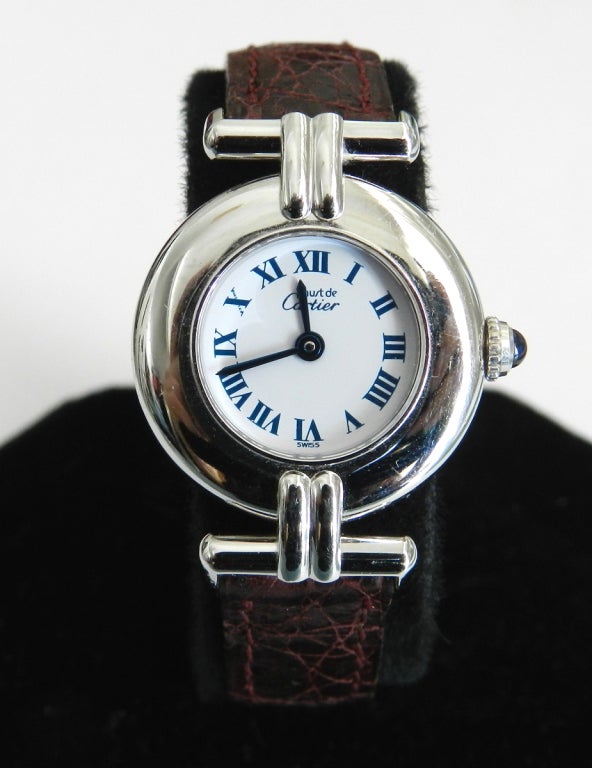 Vintage Must de Cartier ladies watch. Silver with sapphire turn, dark mahogany leather band. No original box. Measures 7/8