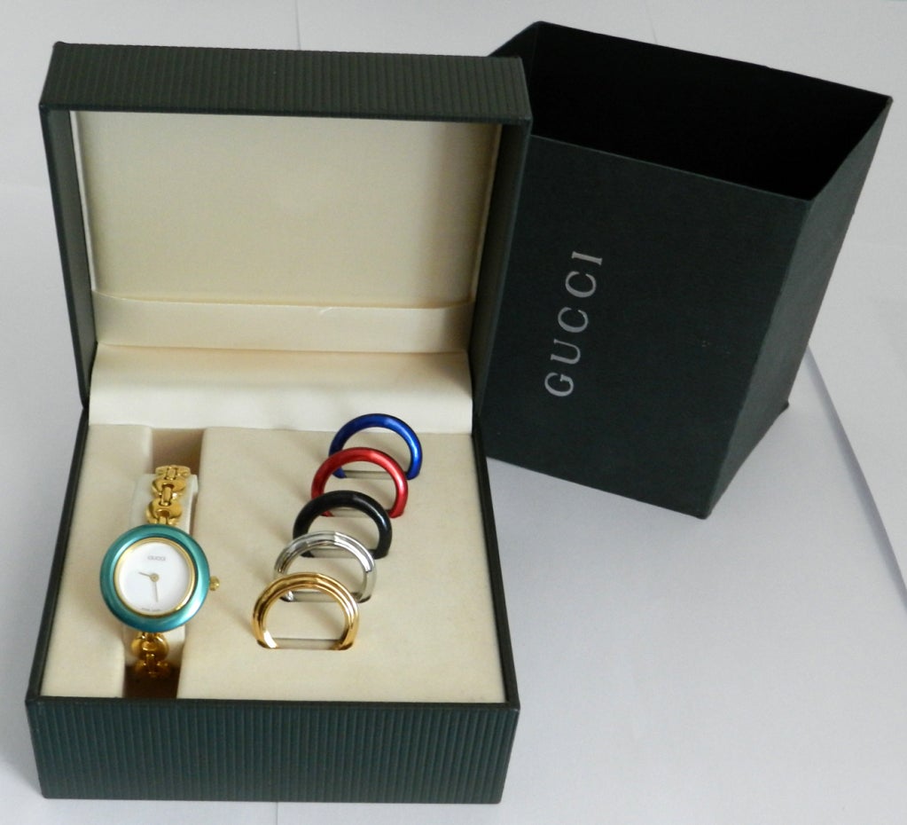 Gucci goldtone link watch with interchangeable bezels.  Measures 6.5