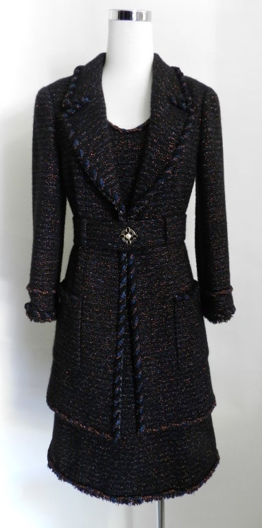 Chanel 07A tweed dress and matching 3/4 length jacket.  Dress is sleeveless and zippers up centre back, and has hidden front hip pockets.  Jacket has enamel and pearl cross button at centre front, and cuffs. Fabric is black with dark blue and
