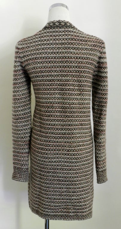 Chanel 07A cardigan sweater. Fastens at front with two hook and eye closures. material content is 63% cashmere, 17 wool, 17, yak, 2 poly, 1 nylon.  Colours are dark red, grey, ivory, black, gold metallic thread, and greyish brown.  Buttons are