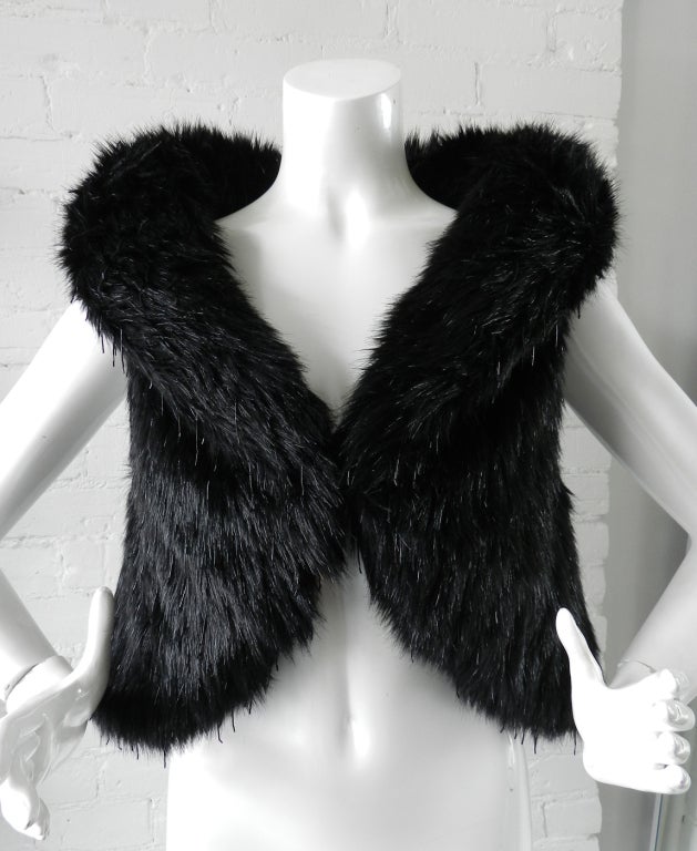 Chanel fantasy faux fur vest. Has fold-down collar, fastens at front with hook and eye closure, and is decorated with glass bead :fringes. Tagged Chanel size 38. Material is 85% modacrylic and 15% poly.

Measurements:
bust to fit 36