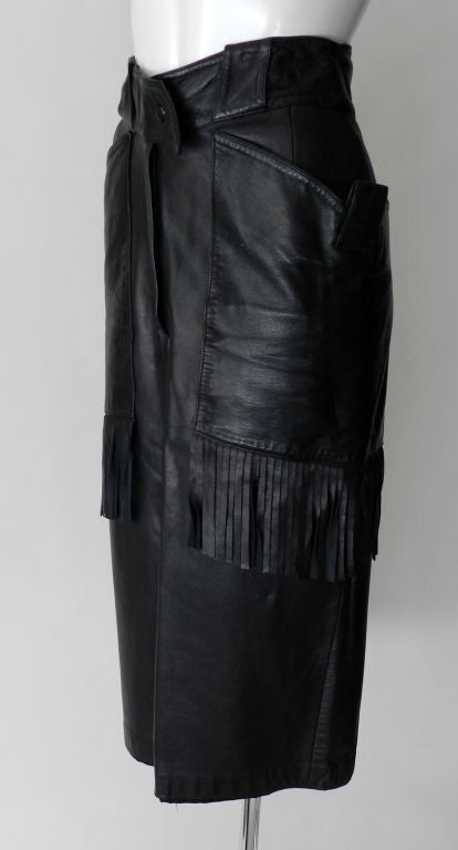 Claude Montana 1980's black leather lambskin skirt.  Wide waistband snaps closed at pointed end, and hip pockets have fringed design. Excellent vintage condition.<br />
<br />
Measurements:<br />
approx. size 2<br />
tagged vintage size 38<br