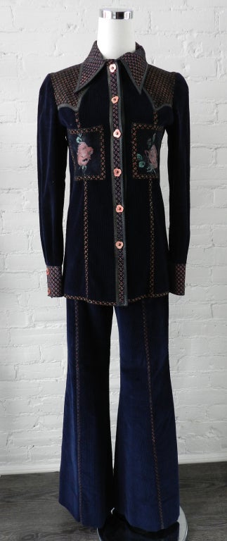 Roberto Cavalli vintage 1970's pants suit. Navy corduroy fabric trimmed with matching navy floral painted suede and decorated with enamel on metal snap buttons. Excellent vintage condition. Pants are high waisted with flare legs, and jacket has