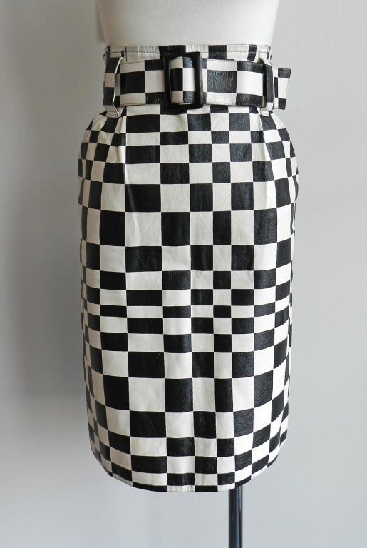 Vintage 1980's black and white graphic check skirt in leather by Charles Jourdan. Skirt has back zipper, matching belt, and side hip pockets. Very good vintage condition. 29