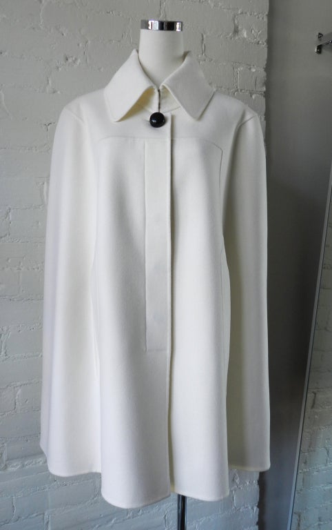 Celine winter white color cape. Light spring weight double faced 85% wool (no lining) and 15% cashmere so it is soft. A large black domed button at neck, and hidden buttons down front. Excellent clean condition as if worn once. Tagged size Celine
