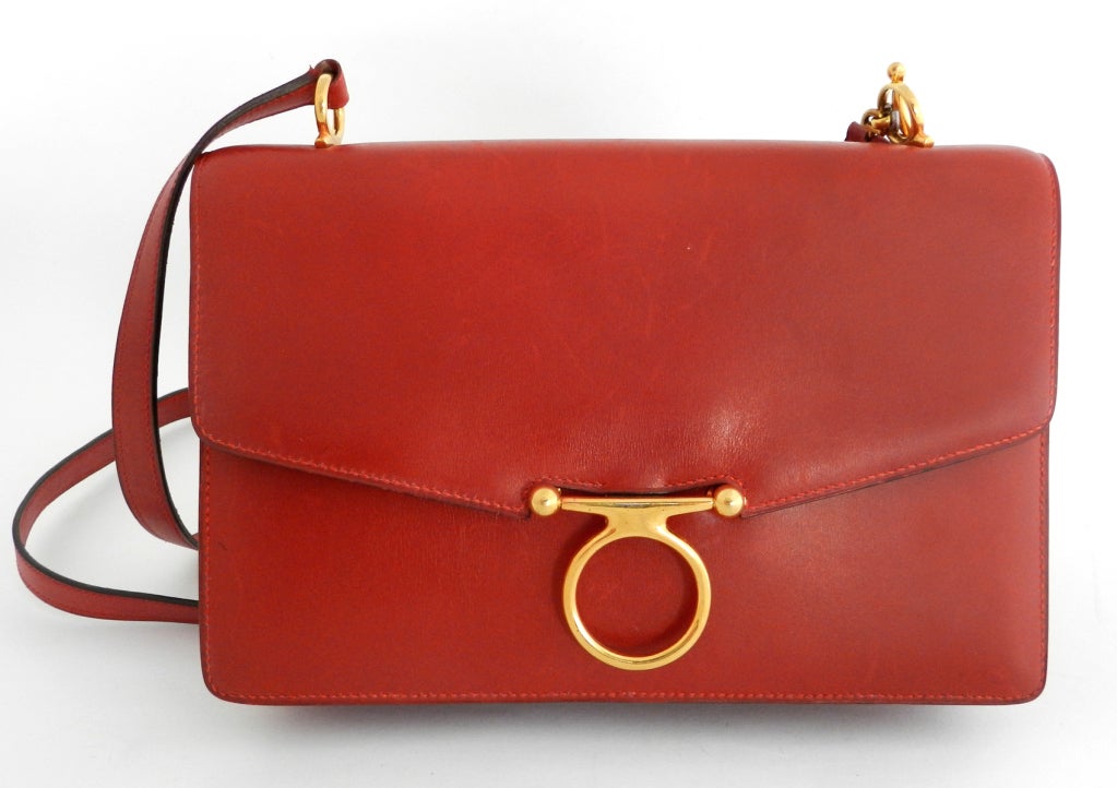 Hermes red leather vintage shoulder bag in box leather. Interior is lined in soft calfskin leather. Goldtone horsebit hardware. Zipper pull inside has date stamp for 1980 (J in circle).  Body measures 9.25