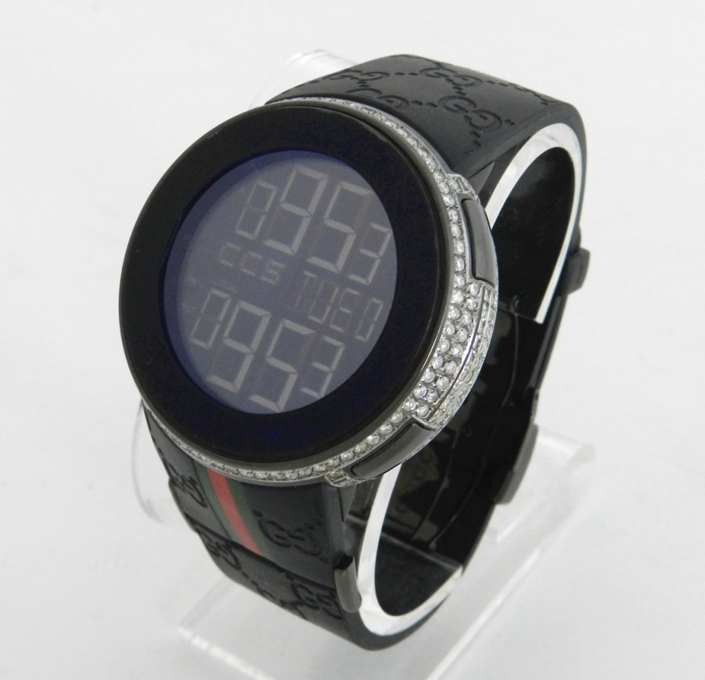 Gucci I-Gucci watch in black. Bezel is set with 5 carat total weight of white diamonds.  Model is 114-2 with black logo rubber band and stainless setting. Face measures 1.75
