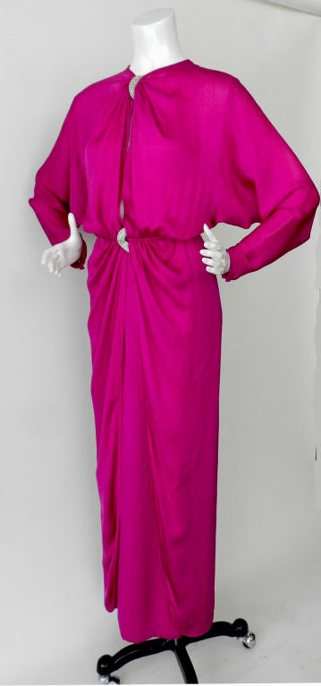 Valentino evening dress in bright jewel-tone fuchsia/magenta. Circa early 1980's.  Dress is silk and has two rhinestone beaded accents at front neck and waist.  Batwing sleeves, fitted waistline, fitted column skirt with overskirt that splits at