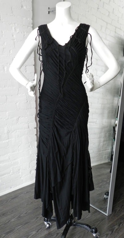 Issey Miyake black sleeveless long dress with ruched details and braided jute rope fringe.  Pull-over design with no zippers or closures.  Material is cotton jersey. Tagged Miyake size 3 - about a USA medium to fit size 4/6/8.  

To purchase this