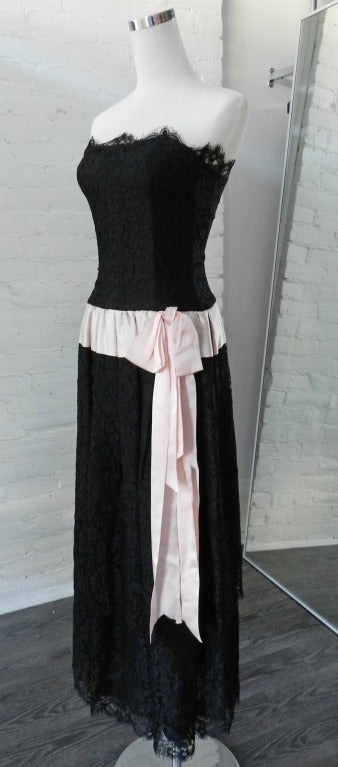 Chanel vintage black strapless lace tiered dress with pale pink satin trim.  Bow is stitched on but can be removed.  Bodice is strapless and boned.  Lined with silk.  Tagged size 38 but fits like a Chanel 34 and is a USA size 0 or XXS.  Bust is 30