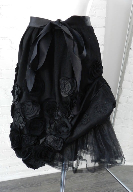 Oscar de la Renta black wool skirt with silk rosettes.  Excellent condition - worn once. Body feels like a soft felt wool and is 50% wool, 40 angora, 10 cashmere.  Silk satin sash and rosettes.  Tagged size 4.  26