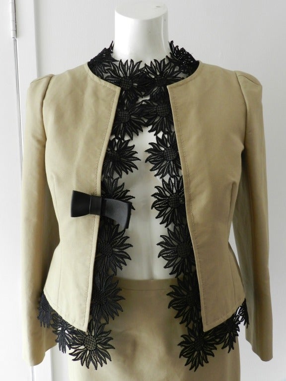 Valentino beige cotton skirt suit with black lace trim. Fitted pencil skirt, jacket fastens with once centre front snap, trimmed in black lace. Size 4 (to fit 34
