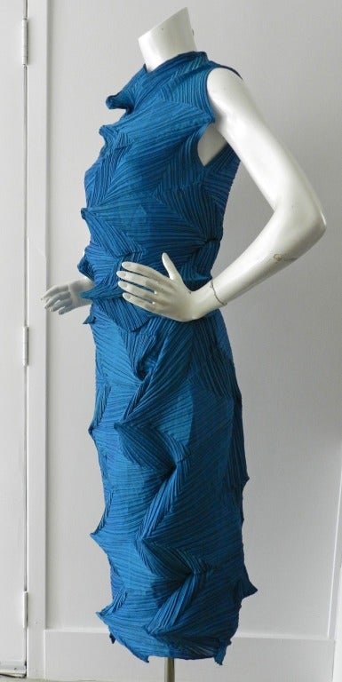 Issey Miyake turquoise blue pleated skirt and tank set.  Skirt has fitted waist band with side button, and matching nylon slip skirt. Tank is a pull-over design and sleeveless. Excellent previously owned condition. Tank is sized Miyake 2 and skirt