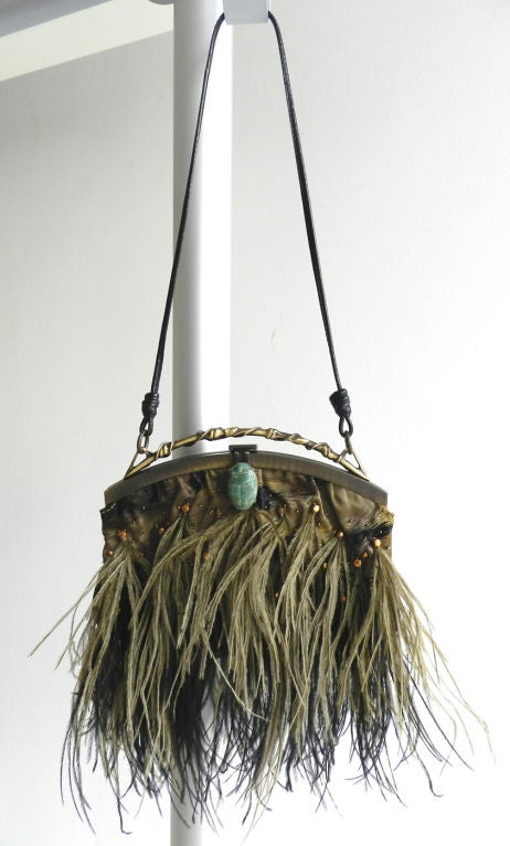 Valentino evening purse with silk fabric body trimmd with olive and black maribou feathers.  Antiqued metal frame has a carved stone scarab beetle clasp and thin leather strap. Fabric is decorated with copper faceted beads and interior is lined with