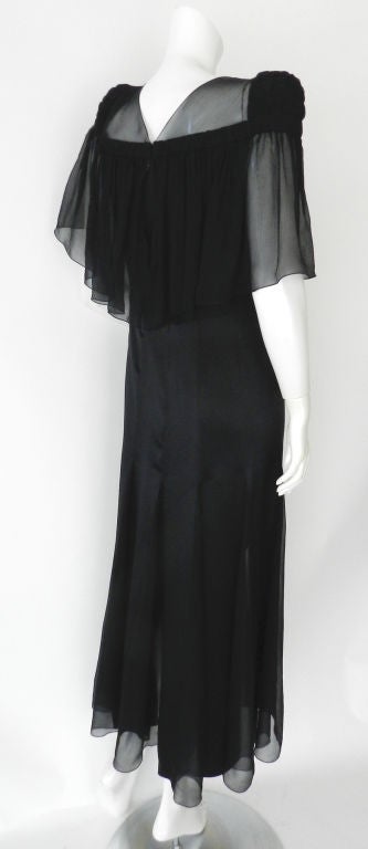 Chanel black silk gown inspired by the 1930's.  Sheer flowing sleeves and bow at centre front.  Dress has sheer triangular panels at skirt and zippers up centre back with CC logo zipper pull. Original retail store tag attached $7220. 100%