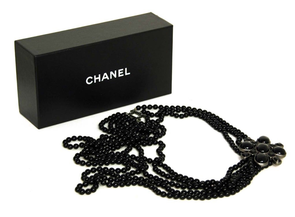 CHANEL Black Multi-Strand Beaded Necklace With Flower Charm

    Age: 2005
    Made In France
    Materials: Beads, Resin, Silvertone Hardware.
    Features Three Draped Beaded Strands With A Jeweled Flower Pin Accent. Other Side Of Flower Has