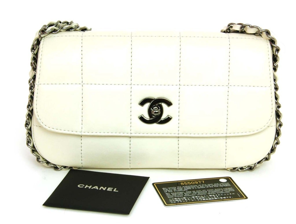 CHANEL White Chocolate Bar Flap Bap With Multi-Chain Strap

    Age: c. 2003
    Made In France
    Materials: White Lambskin, Silver Hardware, Fabric Lining.
    Features Square Chocolate Bar Quilting, 5 Strand Chain Strap. Classic Turnlock CC